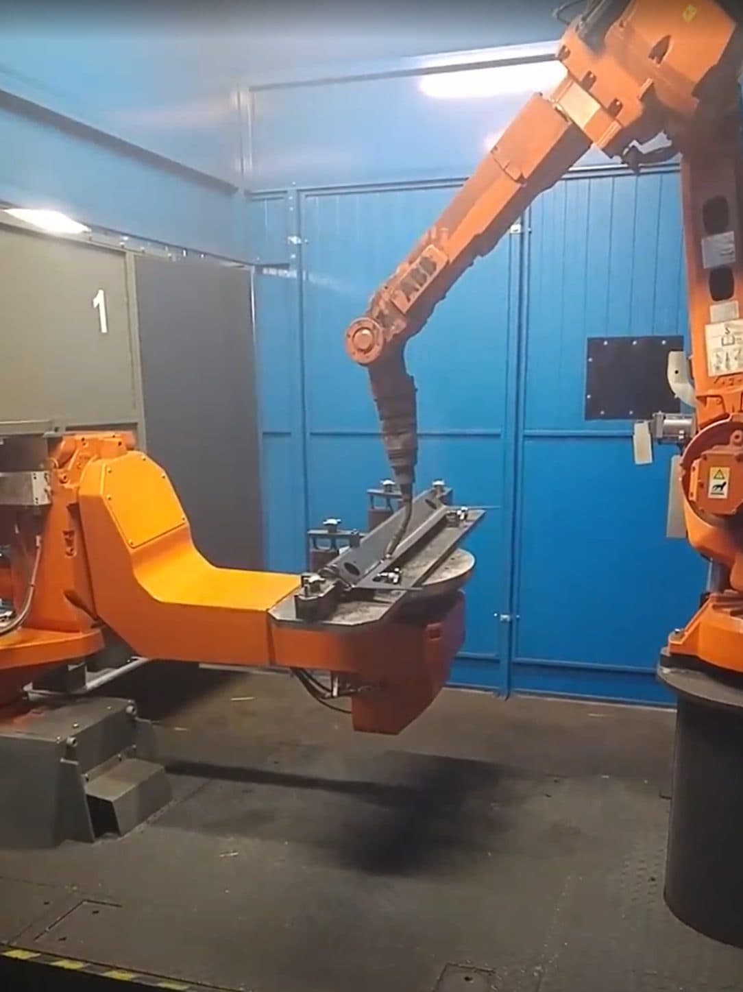 ABB welding robot working on a part clamped to a fixture on a rotating positioner